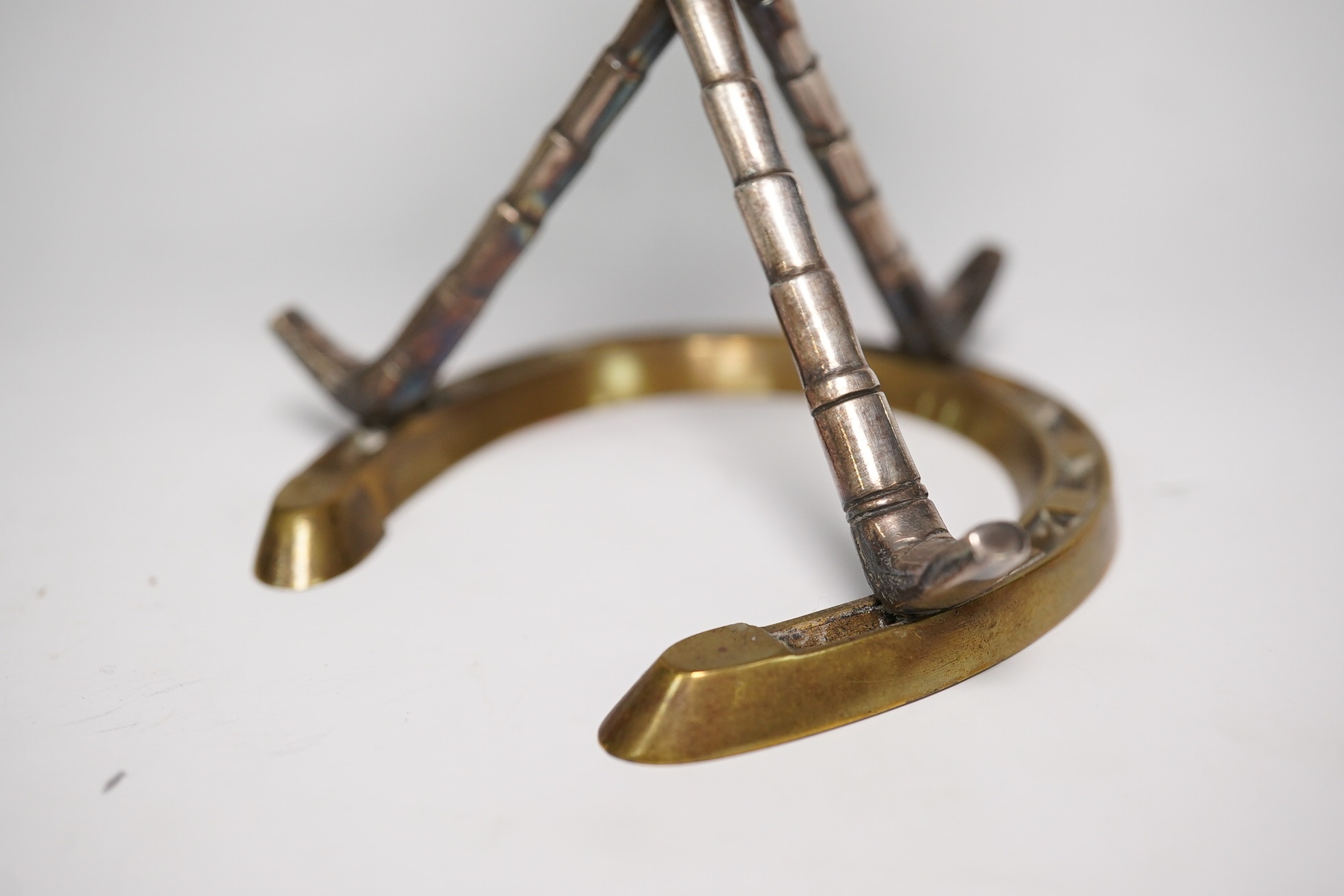 A late Victorian 'equestrian theme' silver plated novelty club lighter, modelled with a riding hat, crops and a horseshoe, 11.7cm. Condition - good